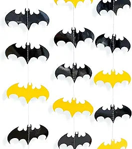 Black and yellow bat cutout decorations on a white sheet, multiple pieces