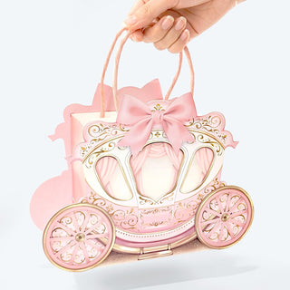 Pink carriage-shaped gift bag with bow-topped handles, front view