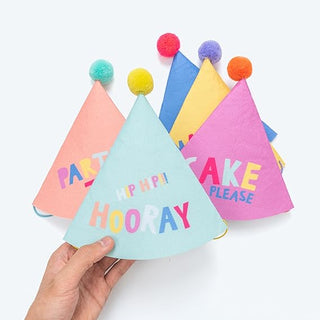 Handheld assortment of party fabric cone hats with pom pom, “MAKE HOORAY” text