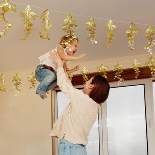 Gold leaf vine garland hanging overhead with curved leaf cutouts, suitable for doorway decor.