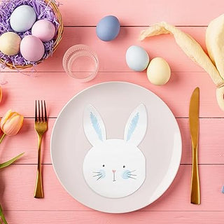 Bunny-shaped paper napkins with light blue ears, set beside a plate