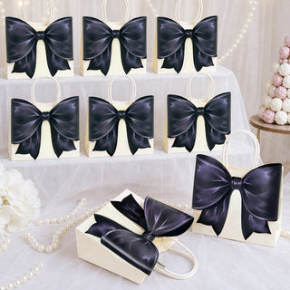 Set of cream gift bags with glossy dark navy bows, arranged on table
