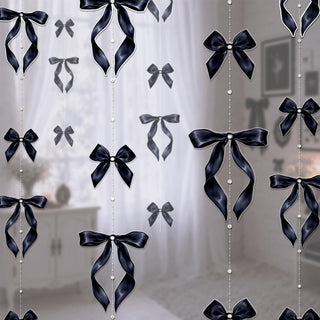 Black satin bow garlands with pearl bead strings hanging on a wall