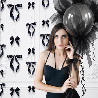 Black bow and pearl garland decorations on wall behind woman