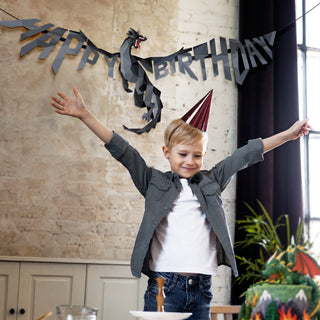 Black dragon happy birthday banner stretched above boy, with geometric dragon and HAPPY BIRTHDAY