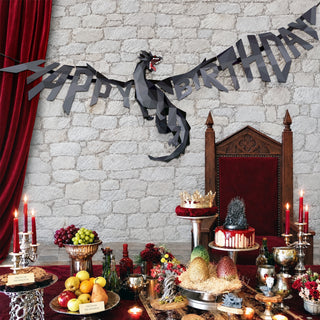 Black dragon happy birthday banner with geometric dragon and HAPPY BIRTHDAY over party table