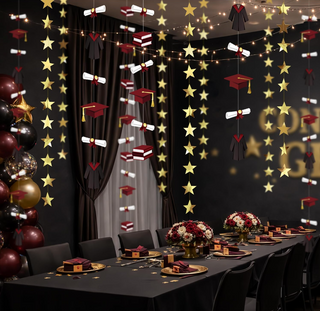 Graduation garland backdrop with gold stars, burgundy caps, black gowns, and diploma scrolls