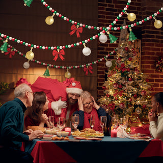 Christmas bead garland with hanging baubles, red bows, and tree charms above fireplace