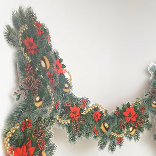 Close-up Christmas garland with pine tips, red poinsettias, and gold ornament baubles