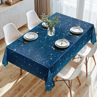 Blue constellation tablecloth on indoor dining table with white chairs and plates