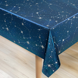 Blue constellation tablecloth draped at corners with star and line pattern close view