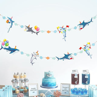 Shark with party hat banner garland with colorful sea-creature cutouts on a string