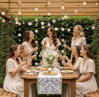 Floral party garland strung above outdoor dining table with daisies and leaves