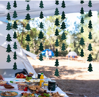 Dark green Christmas tree garland strand hanging outdoors over picnic tent