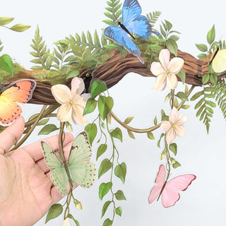 Butterfly and flower wall banner with painted cutouts on leafy vine garland