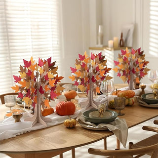 Autumn tabletop tree decor with layered maple leaves in red, orange, and brown on wooden base