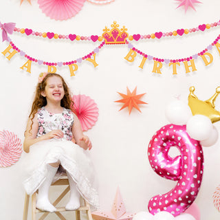 Happy Birthday banner with heart bead garland and golden crown center, pink and gold letters