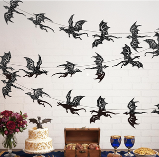 Black glitter dragon wall banner strips across white brick wall, flying silhouette pattern