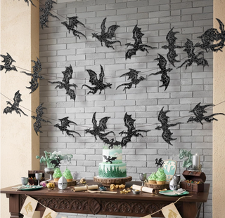 Black glitter dragon wall banner on light brick wall above party table decor