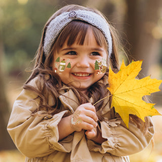 Temporary forest animal face tattoos on a smiling child, with pine trees and mushrooms