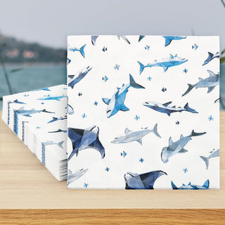 Shark-printed paper napkins, white with blue and gray shark pattern, folded square stack