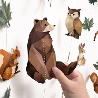 Woodland animal garland strand with geometric bear and raccoon cutouts on a thin string