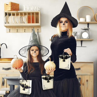 Halloween gift bag held in hand, cream with black crow applique and rope handles