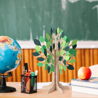 Wooden tree centerpiece with layered green paper leaves on a display base