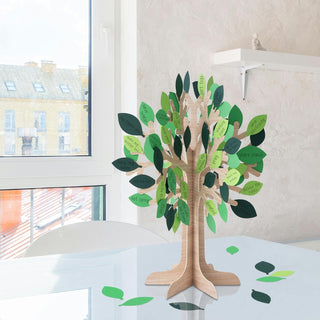 Wooden table centerpiece tree with green and dark leaf cutouts on a base