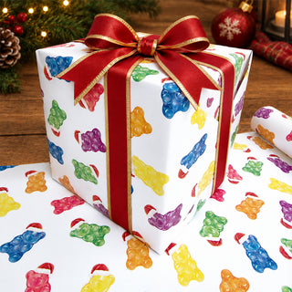 Gift box wrapped in candy bear printed paper with red ribbon bow