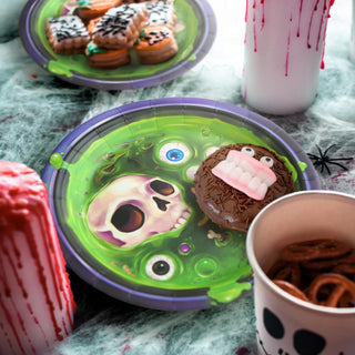 Round Halloween party plate with green skull design and purple rim