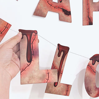 Close-up of Happy Halloween banner letters on red-and-pink stitched fabric flags