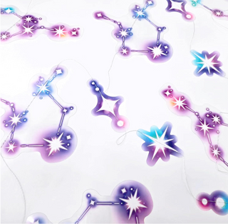 Zodiac-style star and planet ornament pieces with hanging strings, pastel purple and blue
