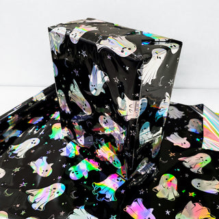 Gift-wrapped box in iridescent Halloween ghost paper with shiny holographic foil finish