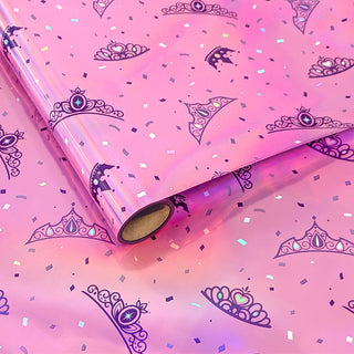 Iridescent pink gift wrap roll with navy princess crown and wand pattern