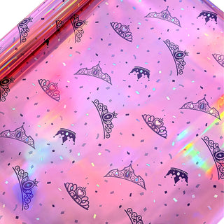 Close-up iridescent pink gift wrap paper with navy crowns and heart designs