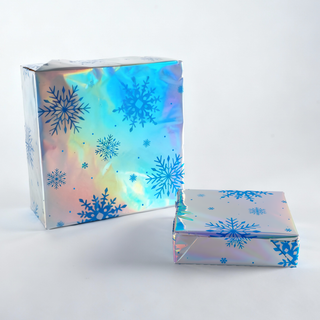 Iridescent gift wrap roll with folded sheet, blue snowflake design and foil sheen