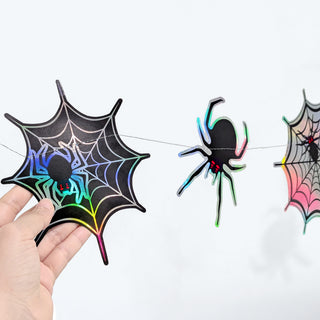 Rainbow iridescent spiderweb decorations with black spiders for Halloween birthday party and spooky home decor