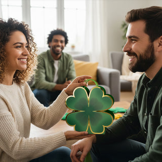Green clover-shaped gift bags with gold trim and handles, held by two people