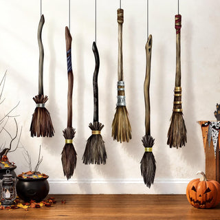 Flying broomstick garland with tall brush broom accents in dark, blue, and tan handles
