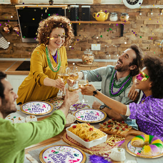 Mardi Gras paper plates with gold trim, "Here to Party Gras!" printed on tabletop