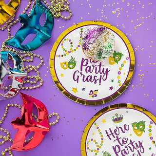 Mardi Gras paper plates with "Here to Party Gras!" print and gold trim, purple accents