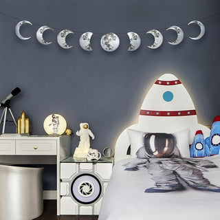 Silver moon banner with nine moon-phase cutouts hanging in a row