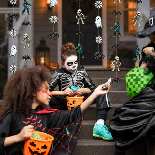 Pixel monster Halloween garland with hanging pixel figures above trick-or-treaters