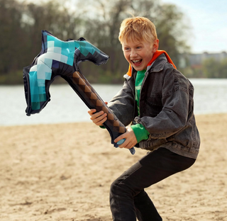 Pickaxe-shaped foil balloon held outdoors, teal and black check with brown diamond stripe