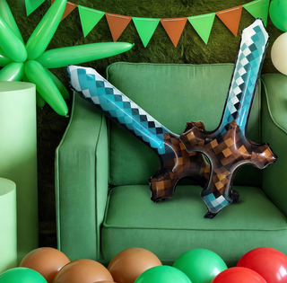 Long sword foil balloon with teal-and-brown check pattern on a green party set