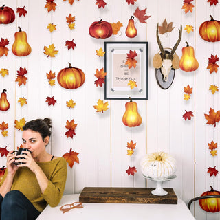 Fall pumpkin and maple leaf garland hanging above mantel decor