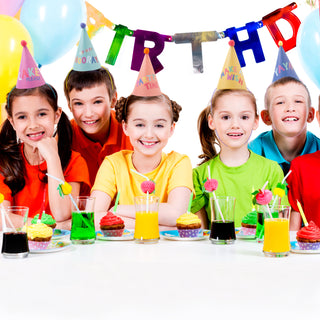 Kids wearing pastel rainbow cone party hats with pom poms in a birthday party