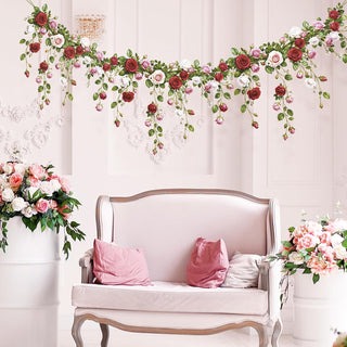 Floral rose garland banner hanging above a chair with pink cushions for party decor