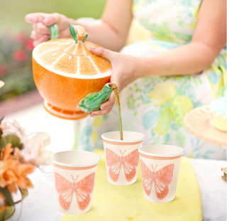 9oz paper cups with orange butterfly design, person pouring a drink into a cup